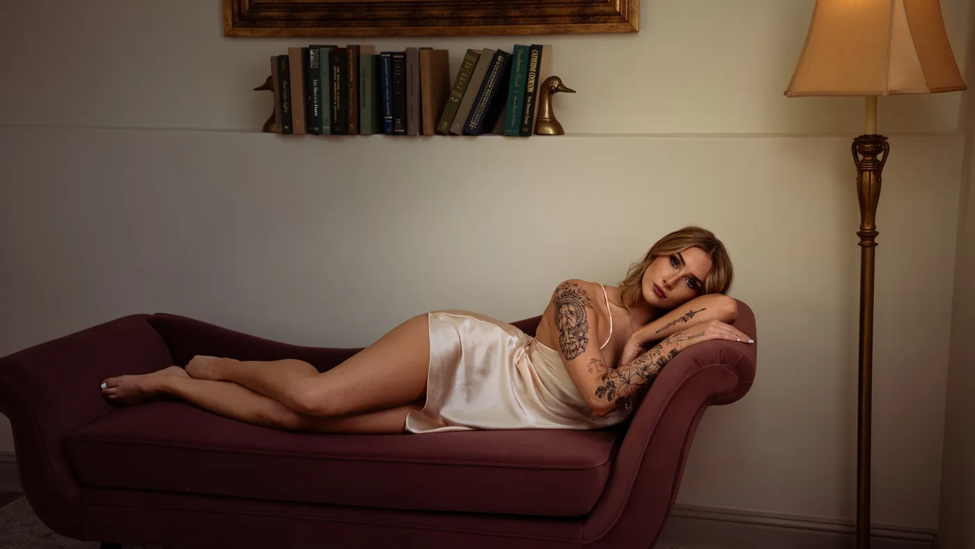 Boudoir portrait in a cream silk slip on a velvet chaise lounge