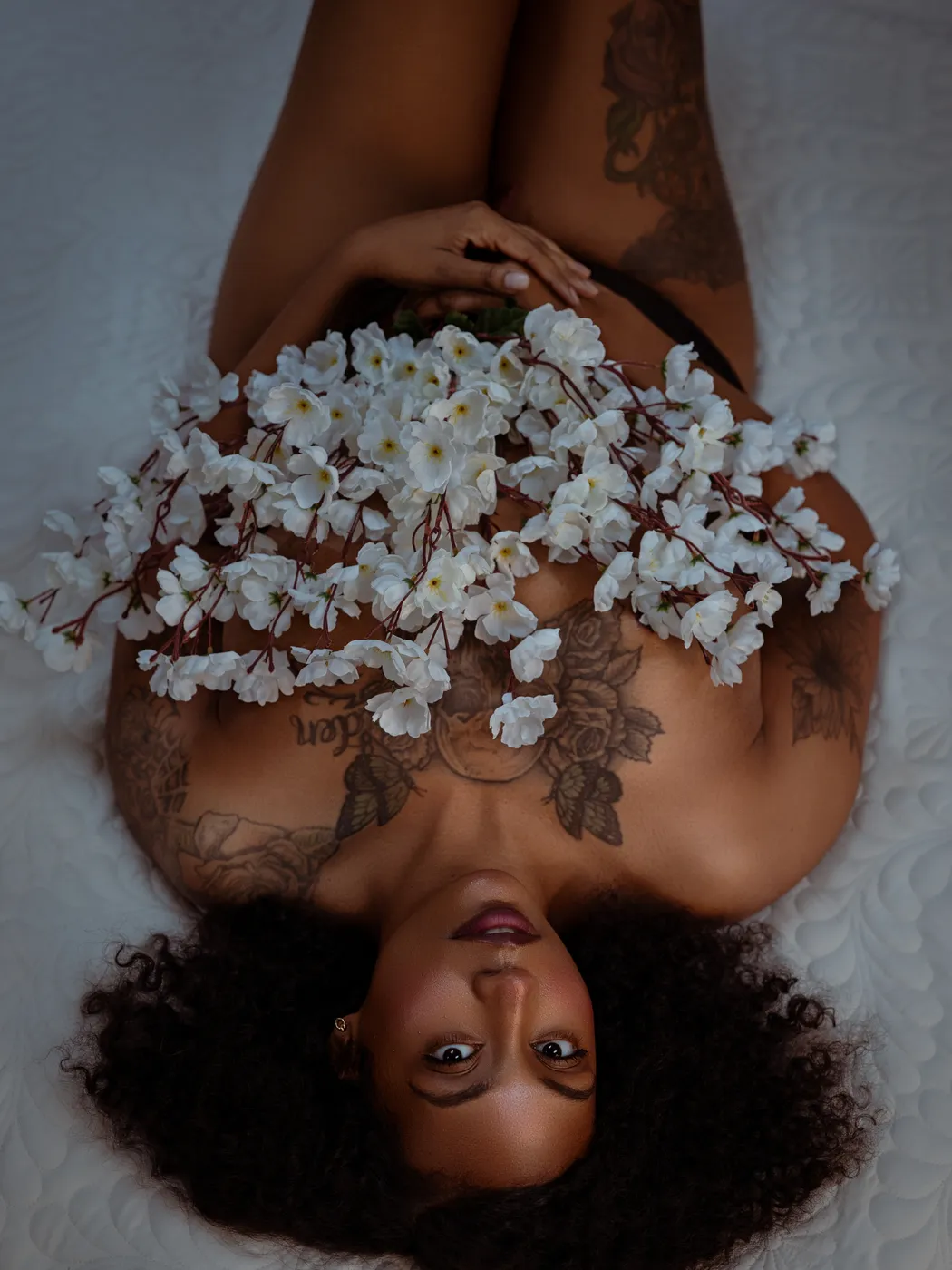Overhead artistic boudoir portrait with white blossoms
